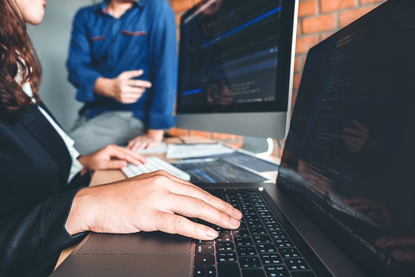 A pair of hands over a laptop screen with code in view